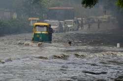 Vehicles wade across a waterlogged street after monsoon rain in New Delhi, on Monday.