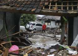 A man walks near debris at a tsunami-ravaged area in Carita, Indonesia