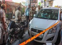 Police personnel inspect the site where two miscreants were shot dead in a gunfight between two notorious gangs, in Dwarka