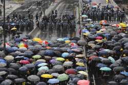 Protesters holding umbrellas face off police officers in anti-riot gear in Hong Kong on Monday, July