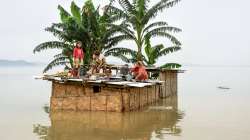 People are seen taking shelter on the roof of their house.