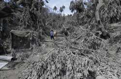 residents walk at their volcanic ash covered village in Laurel, Batangas province, southern Philippi