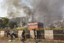 Protestors throw brick-bats during clashes between a group of anti-CAA protestors and supporters of the new citizenship act, at Chand Bagh in Bhajanpura, in north-east Delhi, Monday (PTI)