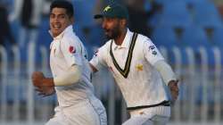 Pakistan pacer Naseem Shah, left, celebrates with teammate Shan Masood after taking the wicket of Bangladesh batsman Mahmudullah during the third day of their 1st test cricket match at Rawalpindi cricket stadium in Rawalpindi