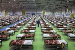 A member of the Iranian army walks past rows of beds at a temporary 2,000-bed hospital for COVID-19 