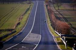 A man rides his bicycle on an empty road in the Taunus region near Frankfurt, Germany, Saturday, Mar