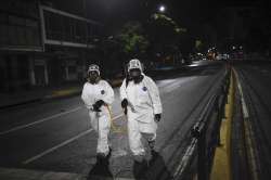 City workers walk after spraying disinfectant on the streets as a preventive measure against the spr