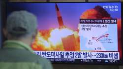 A man watches a TV screen showing a file image of North Korea's missile launch during a news program