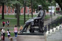 In this Aug. 13, 2019, file photo, students walk past the statue of John Harvard in Harvard Yard at 