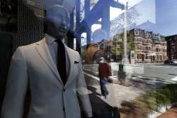 A passer-by wearing a mask out of concern for the COVID-19 coronavirus, background center, walks pas