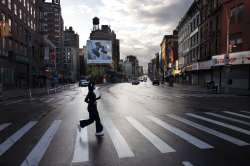 A woman wearing a mask jogs across a quiet section of Canal Street during the coronavirus pandemic M