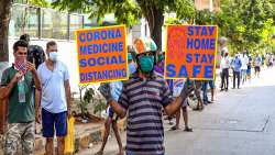  A masked man holds a placard urging citizens to stay at home and maintain social distance outside a wine shop, after authorities permitted the opening of liquor shops with certain restrictions, during the ongoing COVID-19 lockdown, in Mumbai.