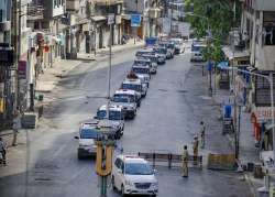 Police vehicles convoy patrol a street during a nationwide lockdown to slow the spreading coronavirus disease, in Ahmedabad, Thursday, May 7, 2020.