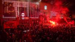 Liverpool soccer fans let off flares outside the Liver Building in Liverpool, England, Friday, June 26, 2020. 