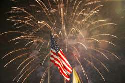  In this July 4, 2015, file photo, fireworks explode behind a United States flag during a Fourth of 