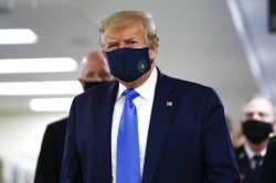 President Donald Trump wears a mask as he walks down the hallway during his visit to Walter Reed Nat