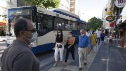 People wearing face masks and keeping social distance to protect against the spread of coronavirus, walk in busy street, in Ankara, Turkey.