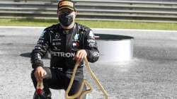 Mercedes driver Valtteri Bottas of Finland poses with his trophy and a bottle of champagne after winning the Austrian Formula One Grand Prix 