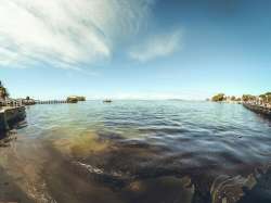 In this photo provided by Grégoire Rouxel fuel is in the ocean leaking from a ship, rear right, that ran aground, Friday, Aug. 7, 2020, in Mauritius. The Indian Ocean island of Mauritius has declared a "state of environmental emergency" after a Japanese-owned ship that ran aground offshore days ago began spilling tons of fuel. Prime Minister Pravind Jugnauth announced the development late Friday, Aug. 7, 2020, as satellite images showed a dark slick spreading near environmental areas the government called "very sensitive."