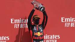 Red Bull driver Max Verstappen of the Netherlands holds up the trophy on the podium after taking first place in the 70th Anniversary Formula One Grand Prix at the Silverstone circuit, Silverstone, England, Sunday, Aug. 9