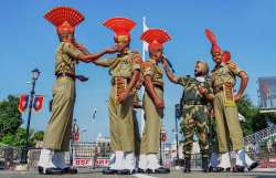 Border Security Force (BSF) soldiers offer sweets to each other during the 74th Independence Day cel