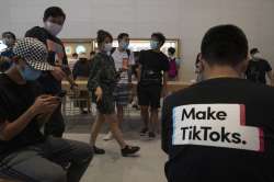 A visitor to an Apple store wears a t-shirt promoting Tik Tok in Beijing on Friday, July 17, 2020. U.S. President Donald Trump on Thursday, Aug 6, 2020 ordered a sweeping but unspecified ban on dealings with the Chinese owners of consumer apps TikTok and WeChat, although it remains unclear if he has the legal authority to actually ban the apps from the U.S.?