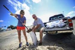  Kim Miller and Monty Graham open their truck bed and began loading up sandbags along U.S. 90 in pre