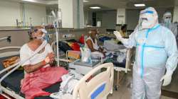 A health worker interacts with a patient undergoing COVID-19 treatment at Neta Ji Subhas Chandra Bos