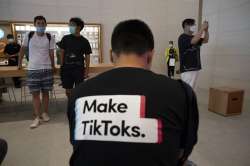 FILE - In this July 17, 2020, file photo, a man wearing a shirt promoting TikTok is seen at an Apple store in Beijing, China. TikTok’s parent company ByteDance has chosen Oracle over Microsoft as a new American technology partner to help keep the popular video-sharing app operating in the U.S., according to a person familiar with the deal.(AP Photo/Ng Han Guan, File)