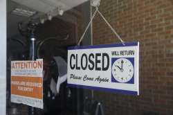 In this July 18, 2020 file photo a closed sign hangs in the window of a barber shop in Burbank, Cali