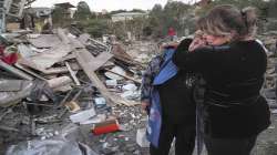 A neighbour comforts home owner, Lida Sarksyan, left, near her house destroyed by shelling from Azerbaijan's artillery during a military conflict in Stepanakert, the separatist region of Nagorno-Karabakh
 