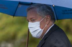 White House chief of staff Mark Meadows glances as he responds to reporters questions outside the We