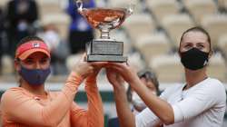 Hungary's Timea Babos,left, France's Kristina Mladenovic hold the trophy after winning the women's doubles final match of the French Open tennis tournament against Chile's Alexa Guarachi and Desirae Krawczyk of the U.S. at the Roland Garros stadium in Paris, France, Sunday, Oct. 11