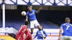 Everton's Dominic Calvert-Lewin, top, scores his side's second goal to make the score 2-2 during the English Premier League soccer match between Everton and Liverpool at Goodison Park stadium, in Liverpool, England, Saturday, Oct. 17