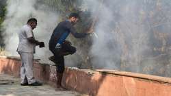 An MCD worker trying to douse a burning garbage heap, in New Delhi