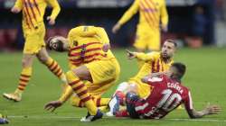 Barcelona's Gerard Pique, left, reacts after getting an injury in a challenge with Atletico Madrid's Angel Correa during the Spanish La Liga soccer match between Atletico Madrid and FC Barcelona at the Wanda Metropolitano stadium in Madrid, Spain, Saturday, Nov. 21