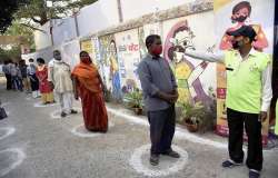 Voters undergo thermal screening at a polling station before casting his vote during the second phase of Bihar assembly elections, amid the ongoing coronavirus pandemic, in Patna