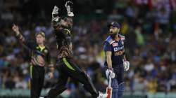 India's captain Virat Kohli, right, watches as Australia's wicketkeeper Matthew Wade, center, jumps to retrieve the ball during the third T20 international cricket match between Australia and India at the Sydney Cricket Ground in Sydney, Australia, Tuesday, Dec. 8