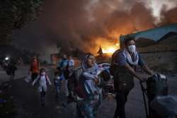 Migrants flee from the second fire in two days at the overcrowded Moria refugee camp on the island of Lesbos, Greece, on Sept. 9, 2020. 