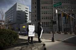 Sasha Tutstone and her son Jaelyn Berry, 9, stand with signs reading "Justice for Andre Hill #blacklivesmatter" and "Cops Stop Killing Black People Our Skin is Not a Crime" in front of Columbus Division of Police Headquarters, Wednesday, Dec. 23, 2020 in downtown Columbus, Ohio. Tutston brought Berry to demonstrate their feelings about the shooting of Andre Hill, who was killed by Columbus Police Officer Andy Coy the night before.