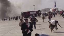 People run following an explosion at the airport in Aden, Yemen, shortly after a plane carrying the 