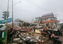 Residents inspect earthquake-damaged buildings in Mamuju, West Sulawesi, Indonesia