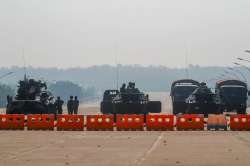 Myanmar's military stand guard at a checkpoint manned with an armored vehicles blocking a road leadi