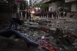 Palestinians search for survivors under the rubble of a destroyed rooftop of a residential building which was hit by Israeli missile strikes, at the Shati refugee camp in Gaza City, early Tuesday, May. 11, 2021