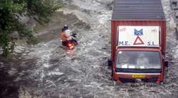 A vehicle moves on a heavily waterlogged road service road of Delhi- Gurugram Expressway after heavy rains on Wednesday