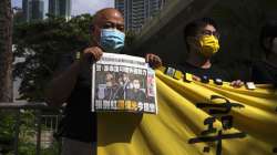 Pro-democracy activists holding a copy of Apple Daily newspaper and banner protest outside a court in Hong Kong, Saturday, June 19, 2021, to demand to release political prisoners