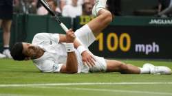 Serbia's Novak Djokovic slips on the grass during the men's singles match against Britain's Jack Draper on day one of the Wimbledon Tennis Championships in London, Monday June 28