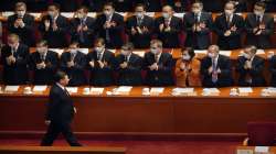 Chinese President Xi Jinping, foreground center, and high ranking officials stand for the national anthem during the opening session of Chinese Peoples Political Consultative Conference.