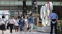 People walk by the Olympic rings installed by the Nippon Bashi bridge in Tokyo 