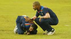 India's Navdeep Saini holds his arm in pain as Shikhar Dhawan attends during second T20I against Sri